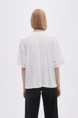 Remera blanca de corte holgado con estampado de flores negras.
