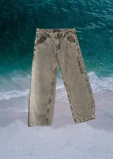 Pantalón de denim gris con efecto lavado, corte ancho y estampado con el texto "Glassy Waves" en la pierna derecha.