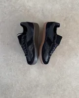 Zapatillas deportivas marrones de cuero vacuno con cordones y suela de goma.