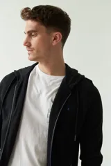 Campera de felpa negra para hombre con capucha, cierre frontal, puños y logo estampado en el pecho.