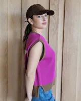 Chaleco tejido color crudo con una estrella gris en la espalda y ribetes marrones.