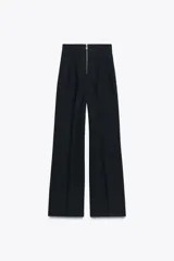 Pantalón negro de tiro alto y corte acampanado, con cierre frontal de cremallera dorada.