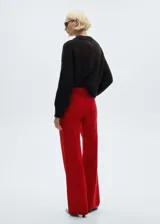 Pantalón de jean recto color rojo, con tiro alto, cinco bolsillos, cierre de cremallera y botón. La modelo mide 1,79 y lleva una talla S/36.