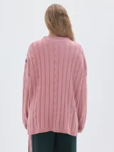 Buzo tejido color blanco, con cuello subido tipo polera, diseño oversized y largo con pequeños cortes laterales.