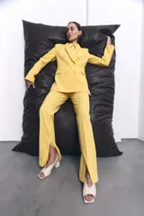 Sandalias de tacón bloque color blanco hueso, con punta cuadrada y talón descubierto. Presentan una tira delgada ajustable con hebilla dorada en el tobillo.