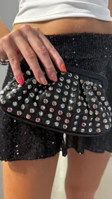 Clutch negro de cuero sintético con tachas plateadas.