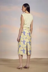Falda midi de tiro alto, corte recto y estampado floral amarillo sobre fondo lila.
