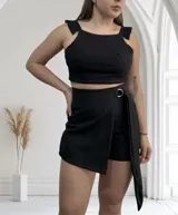 Short pollera negro de corte sastrero con lazo lateral y hebilla metálica.