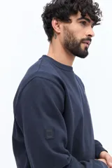 Buzo de algodón color marrón oscuro (ciruela/ciruela quemado) con cuello redondo, puños y ruedo acanalados. Presenta un pequeño bordado de motivos florales en el pecho.