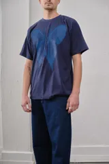 Remera negra oversize de algodón con estampado de mariposa plateada.