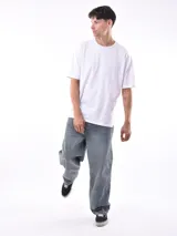 Remera gris de corte oversized, cuello redondo y mangas cortas. 