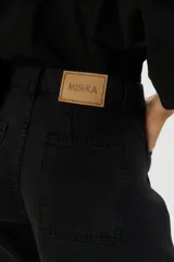Pantalón de jean negro de corte amplio, con tiro alto y detalles de costuras en las piernas.