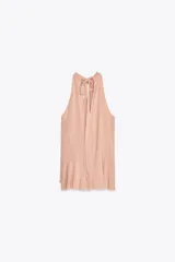 Top color rosa viejo de cuello halter ajustable con lazadas. Detalle de abertura en el delantero y volantes en el mismo tejido.