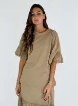 Blusa color beige de corte holgado y mangas cortas con volantes.