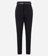Pantalón de vestir negro de corte carrot, con cintura alta, trabillas y cinturón con hebilla metálica.