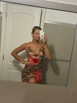 Vestido largo de microtul con estampado animal print y flores rojas. Tiene espalda descubierta con tiras finas cruzadas.