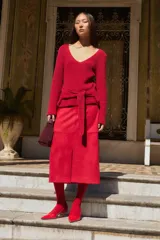 Falda midi roja de simil gamuza, con corte recto y tajo frontal.