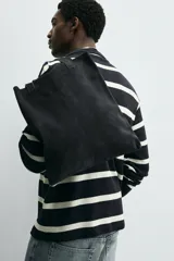 Bolso tipo shopper fabricado en piel con acabado serraje color gris oscuro. Tiene compartimento principal abierto con un bolsillo interior con cierre. Cuenta con dos asas de mano fabricadas en piel.