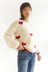 Sweater color crema de lana merino, tejido a mano, con corazones rojos.