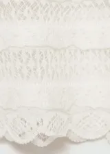 Top de punto fino color crema, con tirantes finos con cierre de lazo, escote cuadrado, diseño calado y terminaciones en contraste.