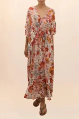 Kaftán largo con estampado floral en tonos naranja, rosa y celeste, con escote en V y cordón ajustable en la cintura.