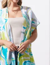 Kimono tejido con estampado abstracto en tonos azul, amarillo y blanco. Tiene mangas amplias estilo japonés y terminación de ruedo con borlas.