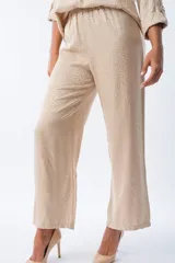 Pantalón palazo color beige con estampado animal print, cintura elastizada y lazo ajustable.