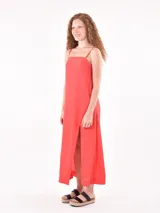 Vestido largo color coral con breteles finos y tajo lateral.