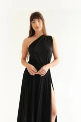 Vestido largo negro de lurex con un solo hombro y falda plisada con abertura lateral.