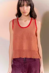 Musculosa de punto color salmón con cuello y sisas ribeteadas en rojo.