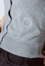 Cardigan gris de tejido de punto con cuello redondo y cierre frontal con botones.