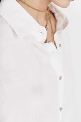 Vestido camisero largo color fucsia, de lino, con cuello camisero, mangas largas, cierre frontal con botones, bolsillos laterales y aberturas laterales en el ruedo.