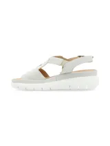 Sandalias de cuero color gris claro con tiras cruzadas y elástico. Suela de plataforma blanca.
