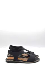 Sandalias planas negras con tiras anchas de neopreno y plantilla de cuero.