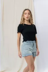 Short de jean azul claro con ruedo doblado fijo, tiro medio, calce cómodo, bolsillos delanteros y traseros, y cierre frontal con botón y cierre.