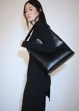Vestido corto negro de punto de canalé con cuello redondo y mangas largas.