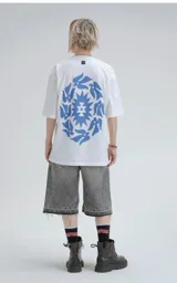 Remera blanca de corte holgado con estampado azul de diseño geométrico y aves.