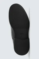 Zapato de vestir estilo derby, color negro, con capellada de cuero, horma redonda y suela de goma con volumen.
