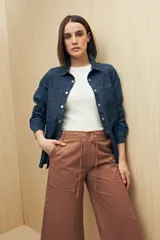 Pantalón capri color beige de algodón, con corte acampanado, bolsillos laterales tipo cargo y cintura con cordón ajustable.