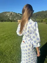 Camisa marrón con lunares blancos, corte clásico, cuello camisero, mangas 3/4 abullonadas y lazo ajustable en la cintura.