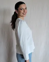 Remera negra de mangas largas con cuello en V y detalles de pespuntes blancos.