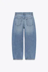 Pantalón de jean celeste de corte amplio, con tiro medio, cinco bolsillos y costuras torcidas.