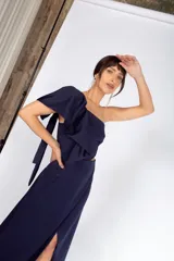 Vestido largo color salmón de un solo hombro, con manga corta abullonada y falda con abertura lateral y volados.