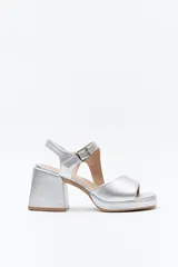 Sandalias plateadas con plataforma fina y taco ancho forrado. Incorporan pulsera con hebilla metálica y capellada ancha.