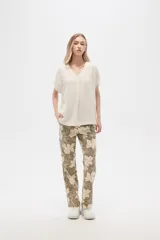 Pantalón de lino color verde oliva con estampado de flores color crema, de corte recto.
