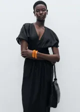 Vestido largo negro con escote en V, mangas cortas y cintura elastizada.