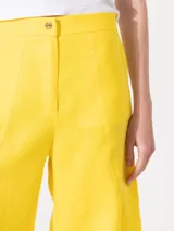 Pantalón blanco de lino, con cierre y botón en el delantero, de fit amplio y cómodo.