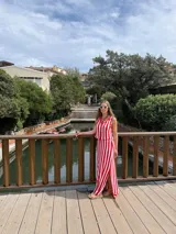 Falda larga tejida a rayas rojas y blancas, con pretina elástica y tajos laterales profundos.