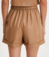 Bermuda color camel de material sintético, con cintura alta, trabillas, cierre con cremallera y botón, bolsillos laterales, pliegues frontales y ruedo con dobladillo.