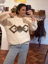 Sweater color crema de tejido de punto con cuello redondo y apliques geométricos metálicos bordados a mano en el frente.
